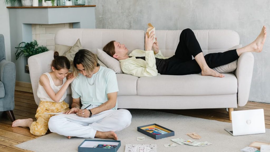 Father and daughter bonding in cozy living room with books and games, creating joyful family moments.